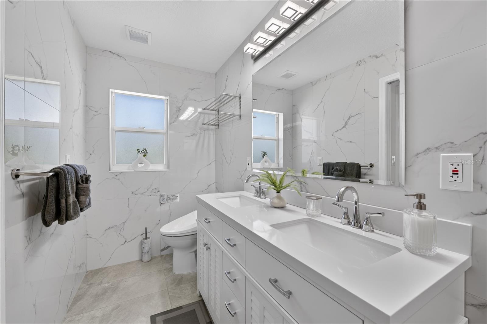 Primary bathroom with double sinks and bide.