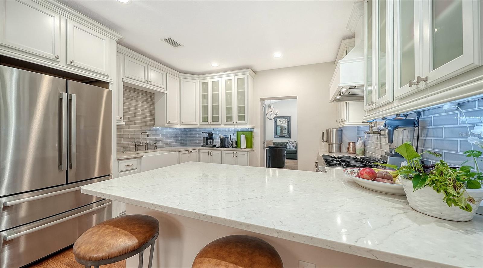 Beautifully appointed chef’s kitchen offers abundant custom cabinetry, premium appliances, quartz countertops, and exceptional workspace.