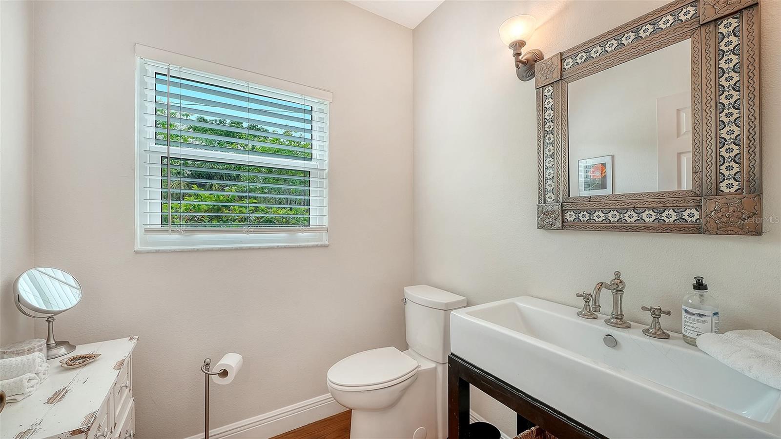 Convenient half bath showcases elevated finishes and thoughtful design consistent with the home’s sophisticated renovation.