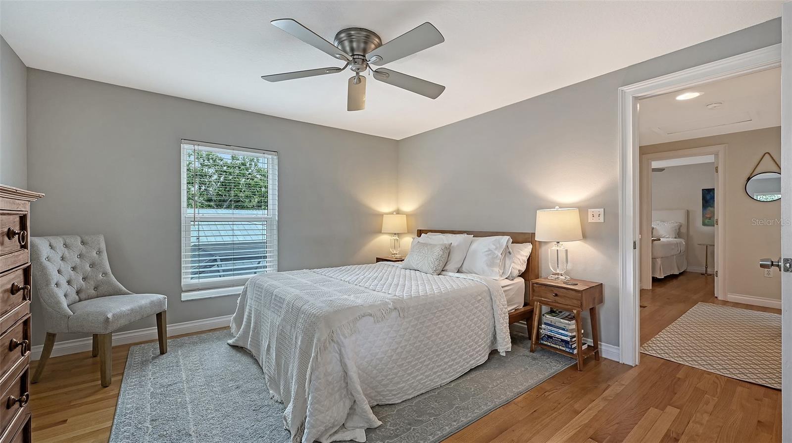 Spacious bedroom offers hardwood floors, abundant natural light, and a serene setting suitable for a luxurious private retreat.