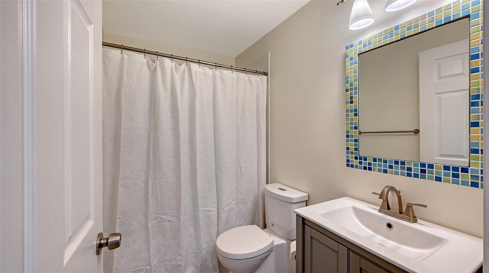 Well-appointed full bathroom features a stylish vanity, quality finishes, and a clean, sophisticated design.
