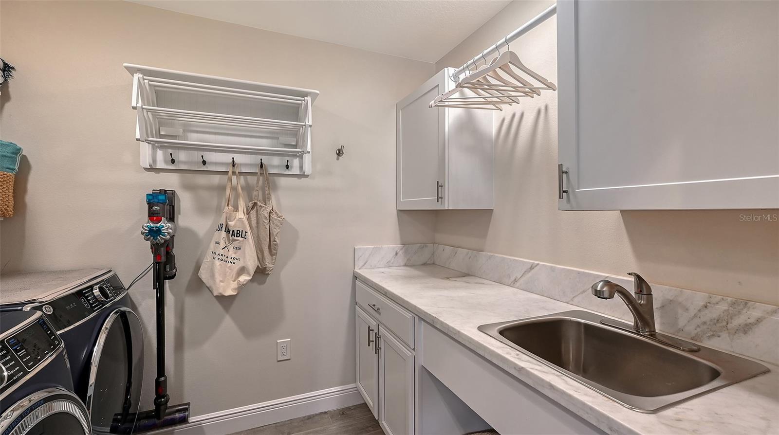 Dedicated laundry room provides exceptional functionality with generous cabinetry, folding space, and premium convenience.