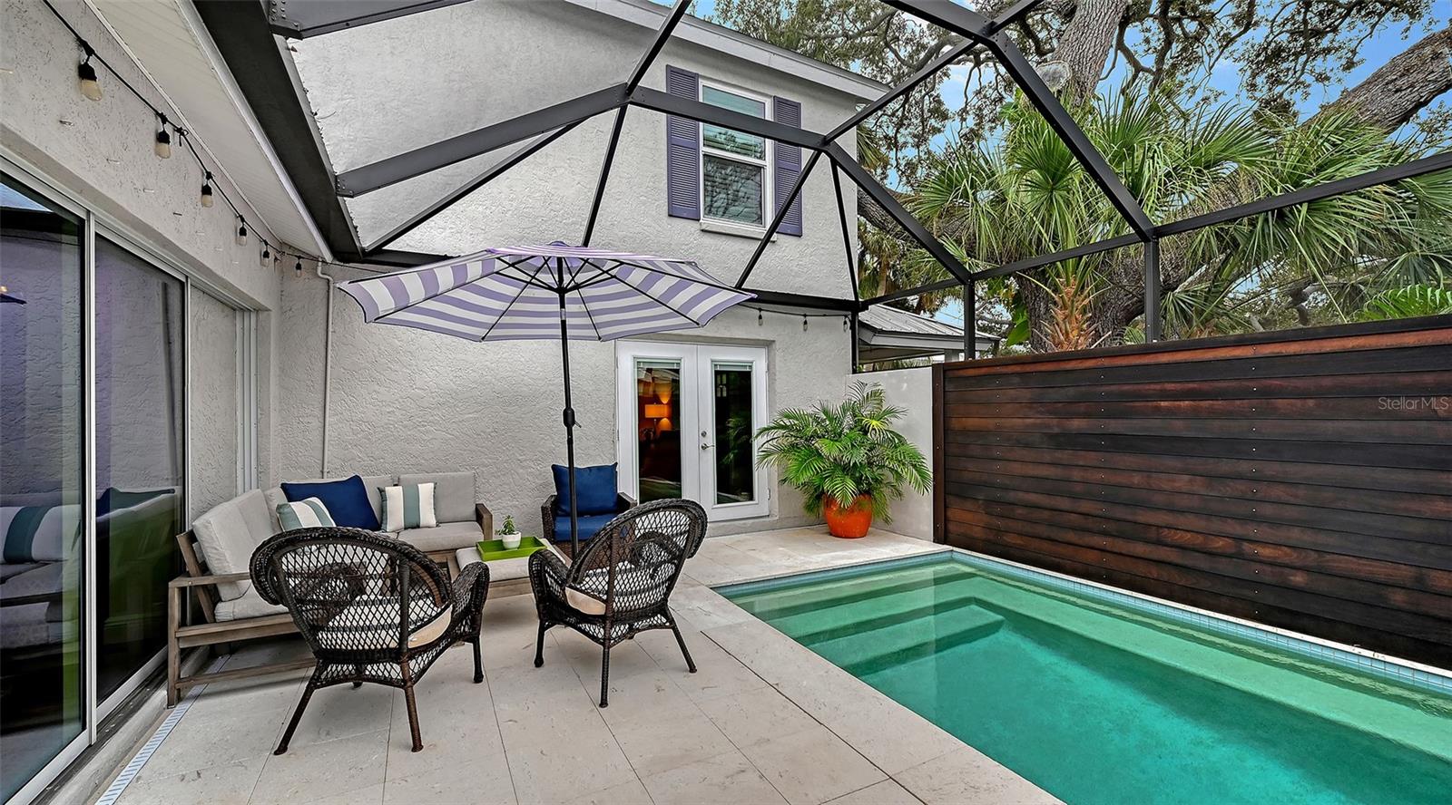 Heated pool and screened courtyard lanai offer a sophisticated private oasis designed for effortless Florida outdoor living.