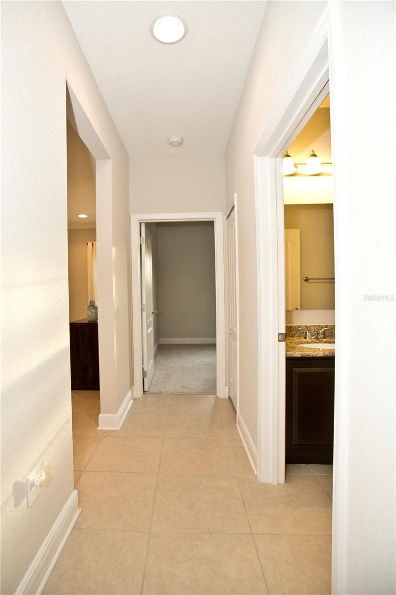 Hallway between two bedrooms and guest bathroom. Linen closet is on the right.