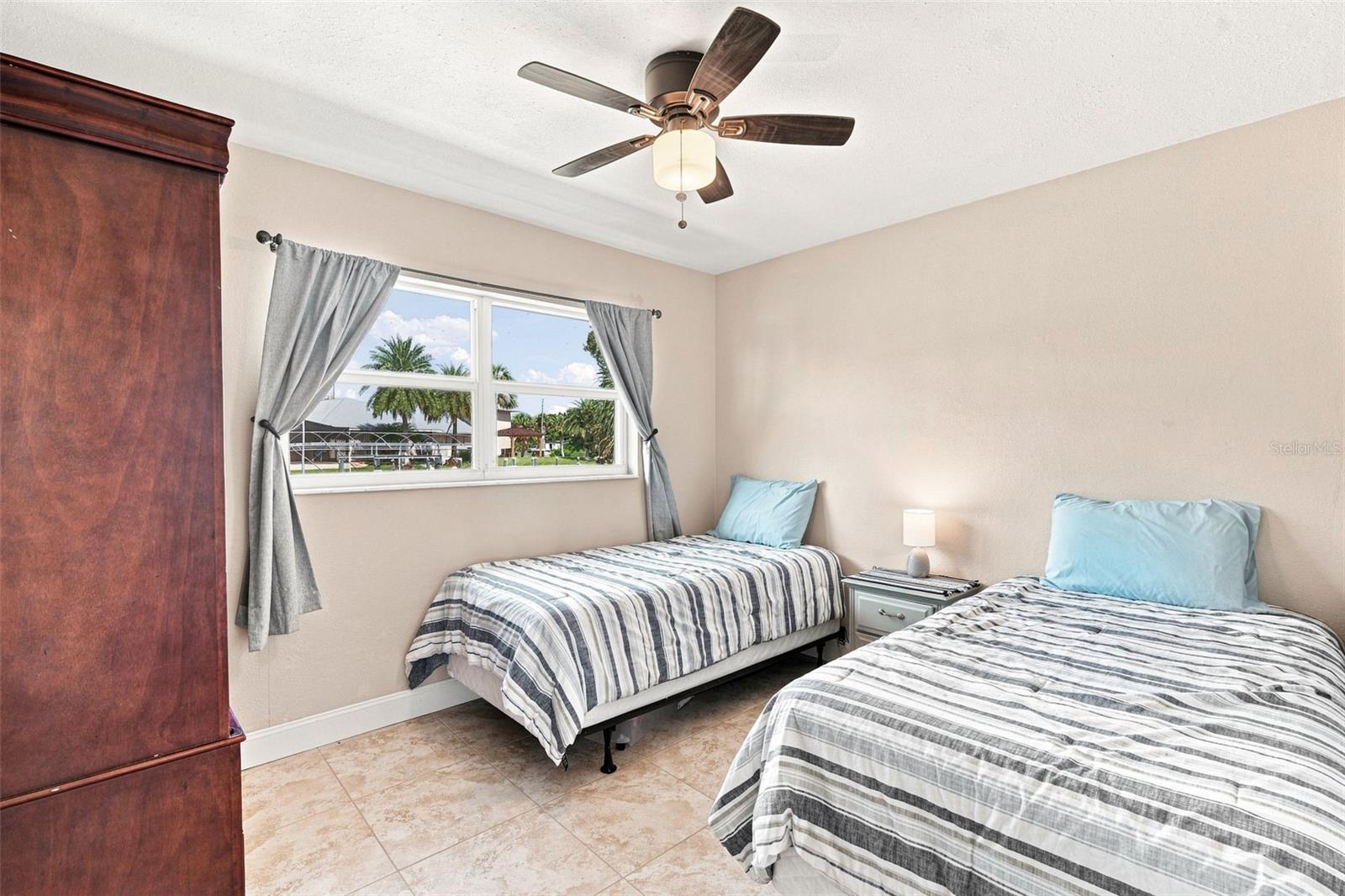 Third Bedroom with Large Window, Ceiling Fan, & Tile Floor