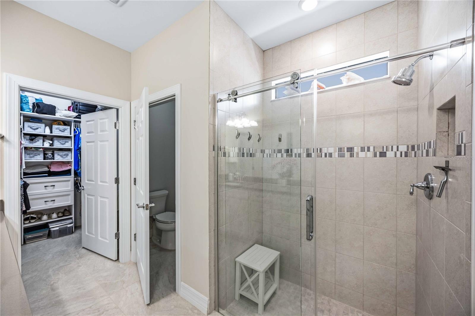 Large Shower and Walk in closet with shelving