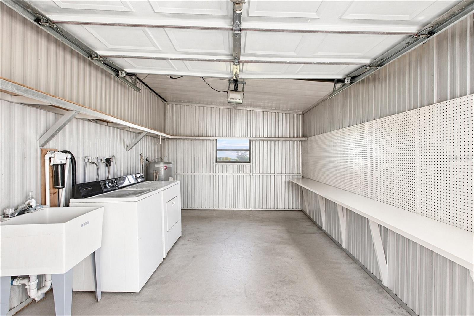 Garage with electric garage door opener and washer dryer with sink
