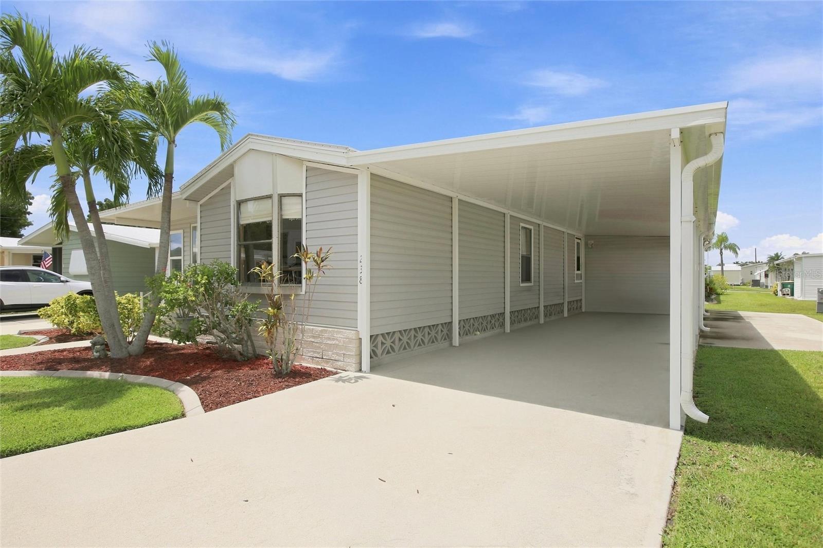 Carport with extra parking pad for trailer or another vehicle