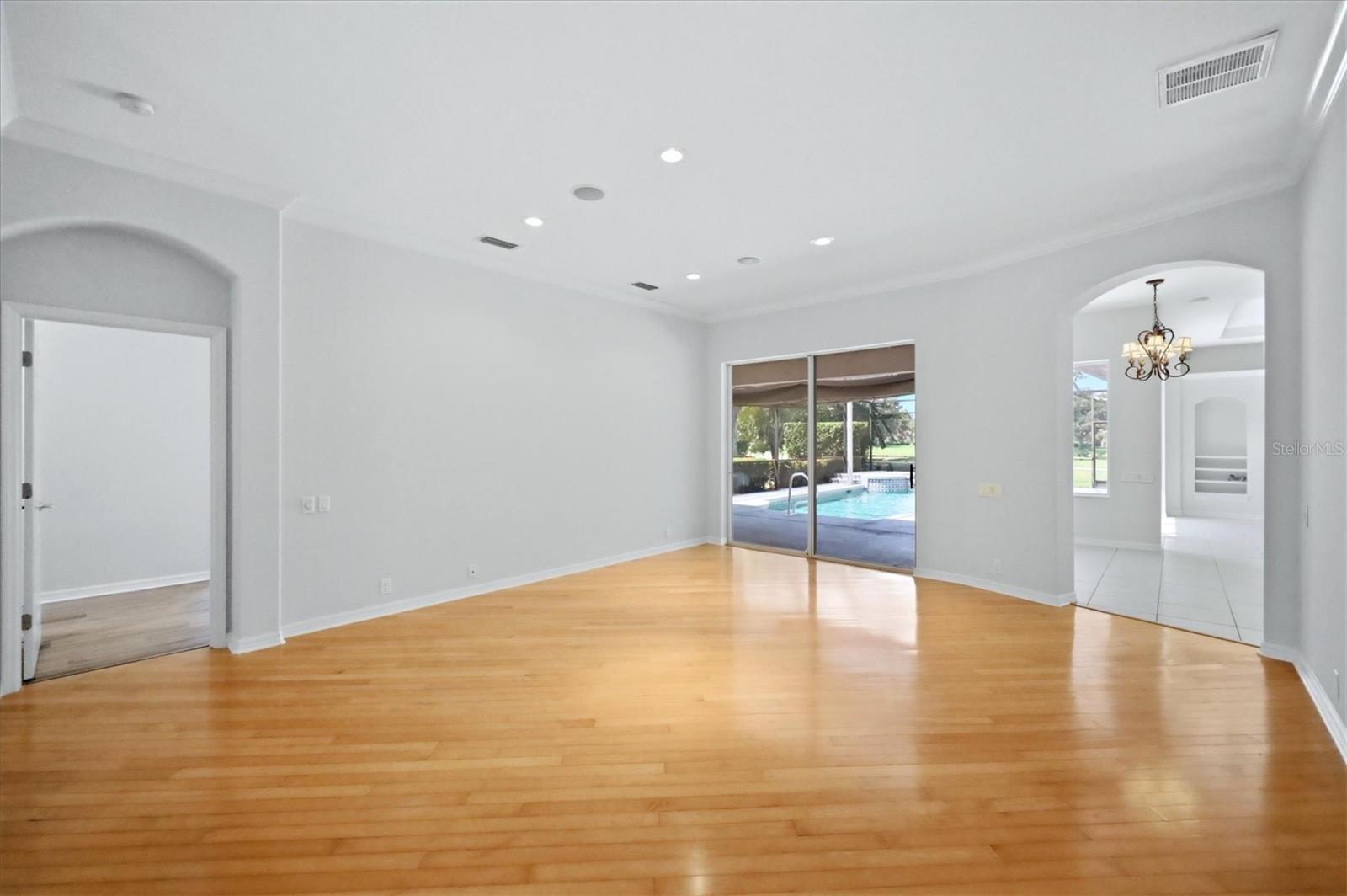 Living area with pool access; primary suite to left; breakfast nook/kitchen area to right